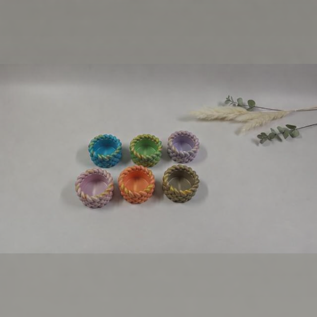 Set of 6 braided tealight candle holders in pastel colors.