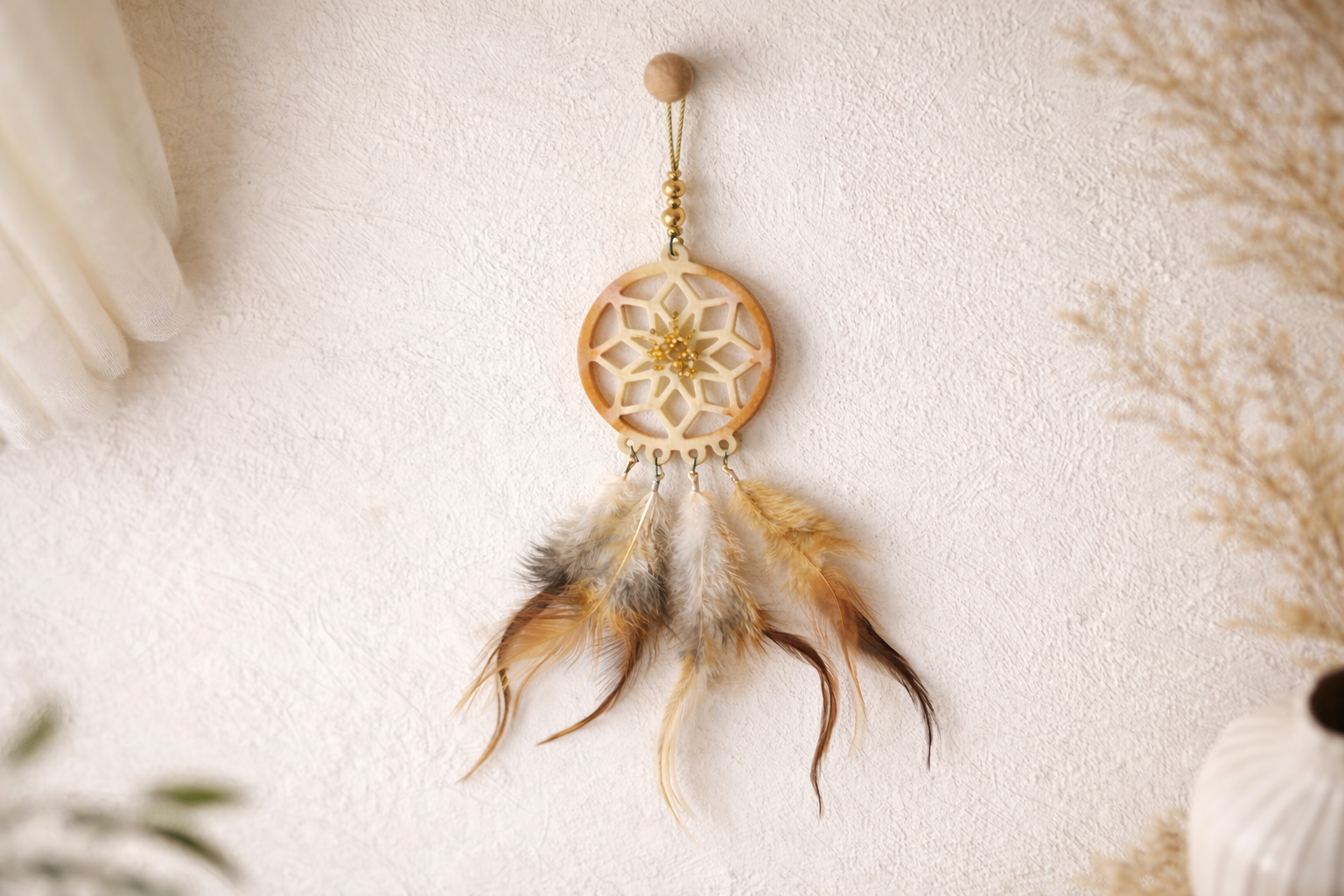 Dreamcatcher with feathers on a light background