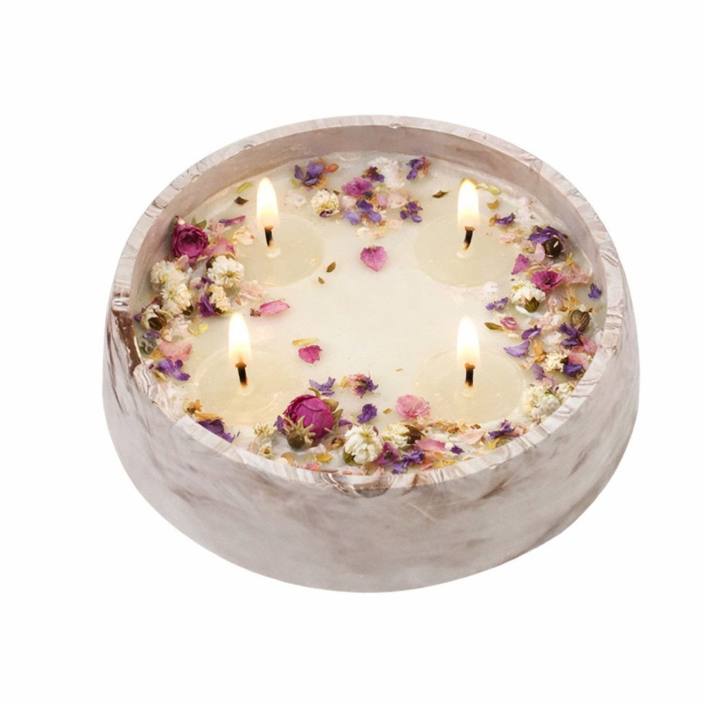 Candle with floral petals in a marble-textured holder on a white background