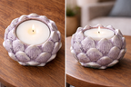Decorative purple candle holder with a lit candle on a wooden surface.