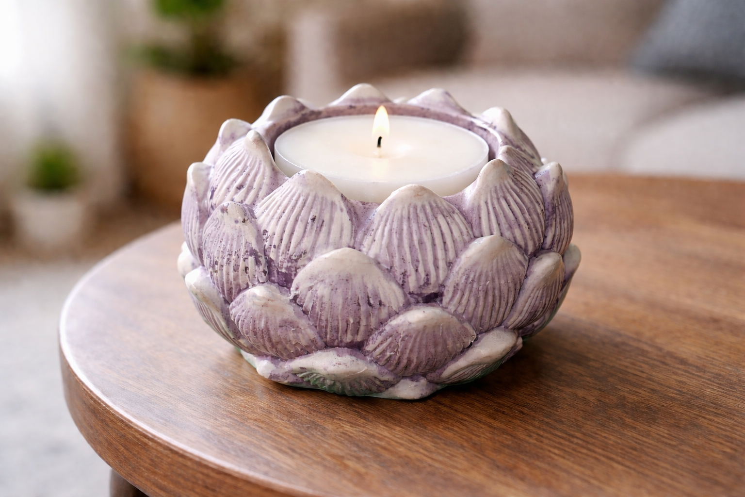 Decorative candle holder with a lit candle on a wooden table in a home setting