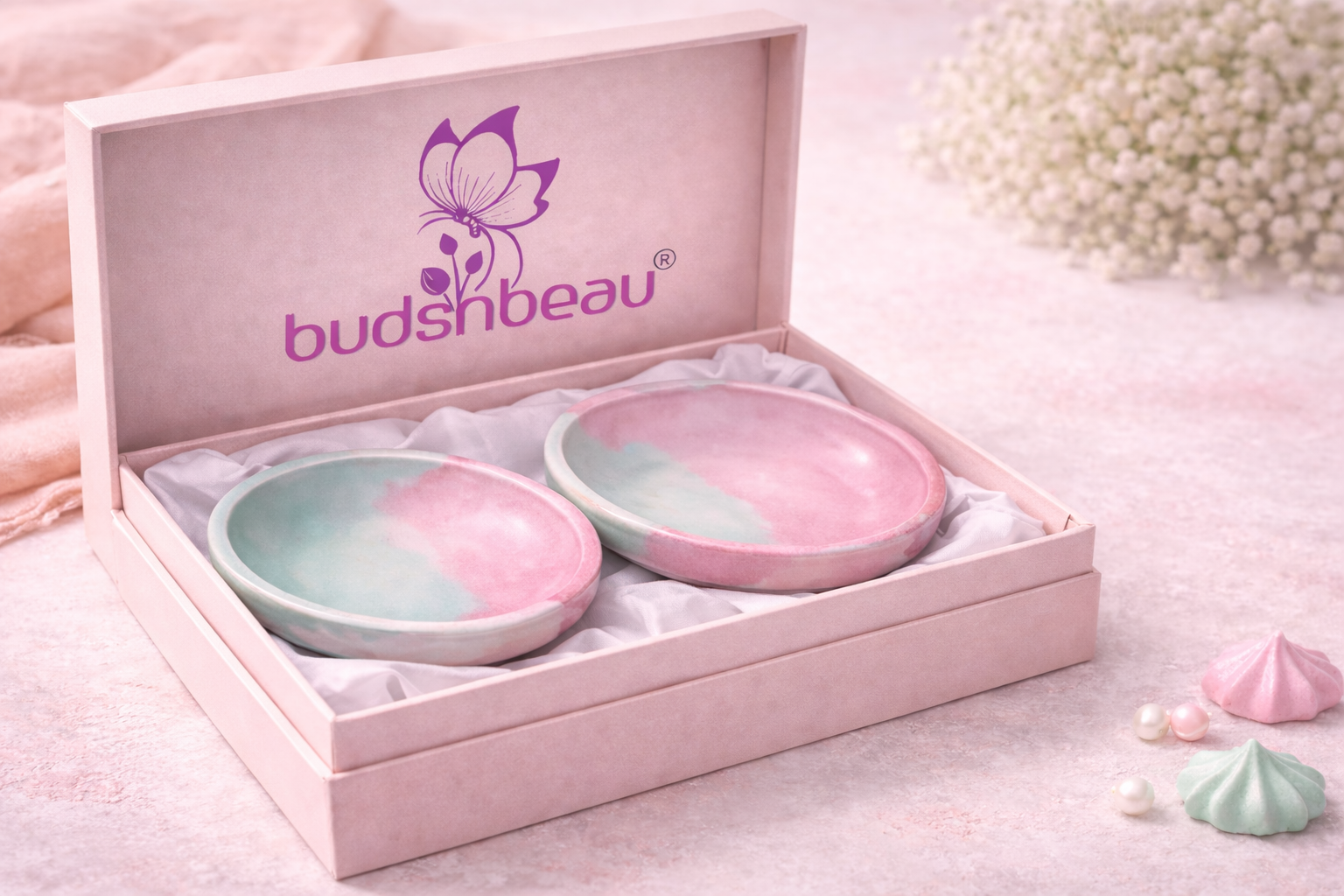 Two pastel-colored bowls in a 'budshbeau' branded box on a soft pink background.