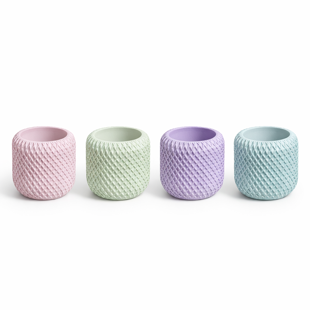Four textured ceramic cups in pastel colors on a white background