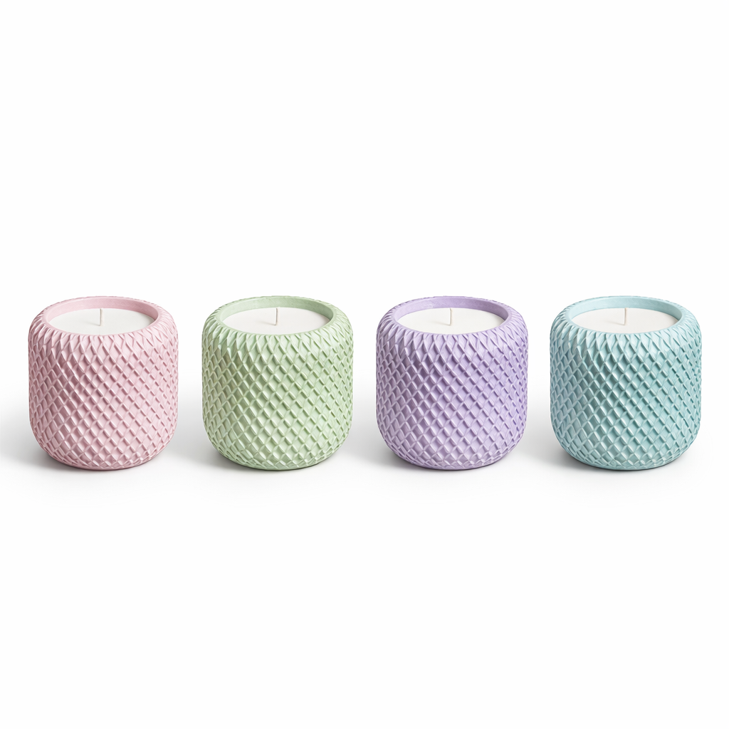 Four textured candles in pastel colors on a white background