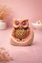 Owl-shaped candle on a pink background