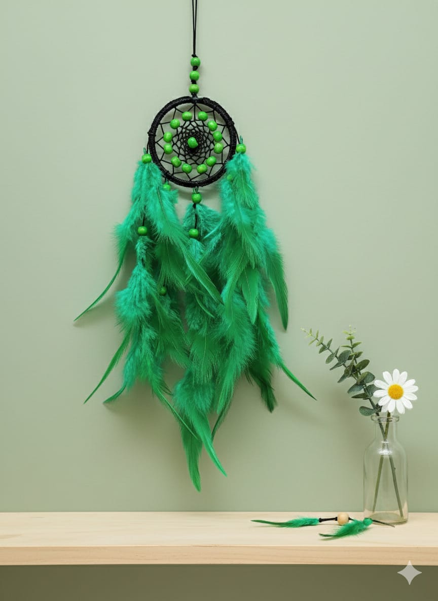 Green dreamcatcher with feathers and beads hanging on a wall.