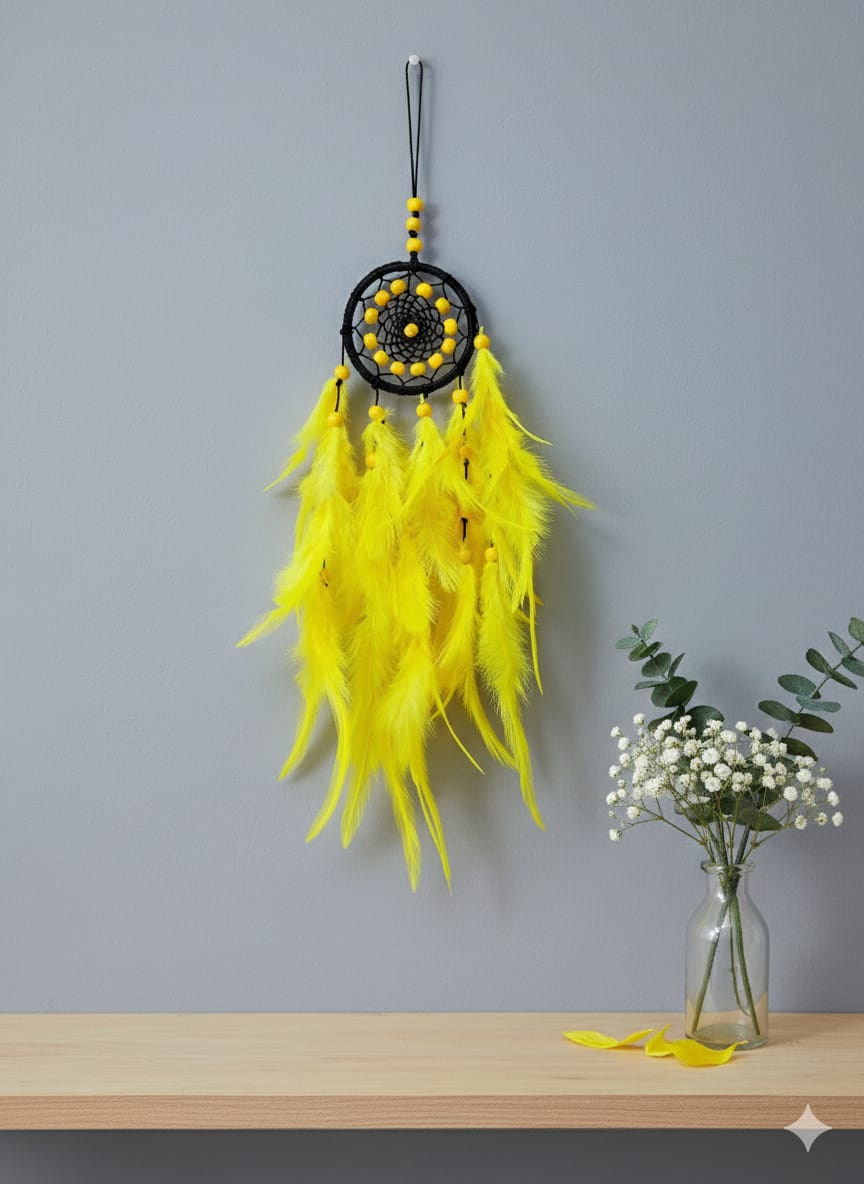 Yellow feather dreamcatcher with black and yellow beads hanging on a gray wall.